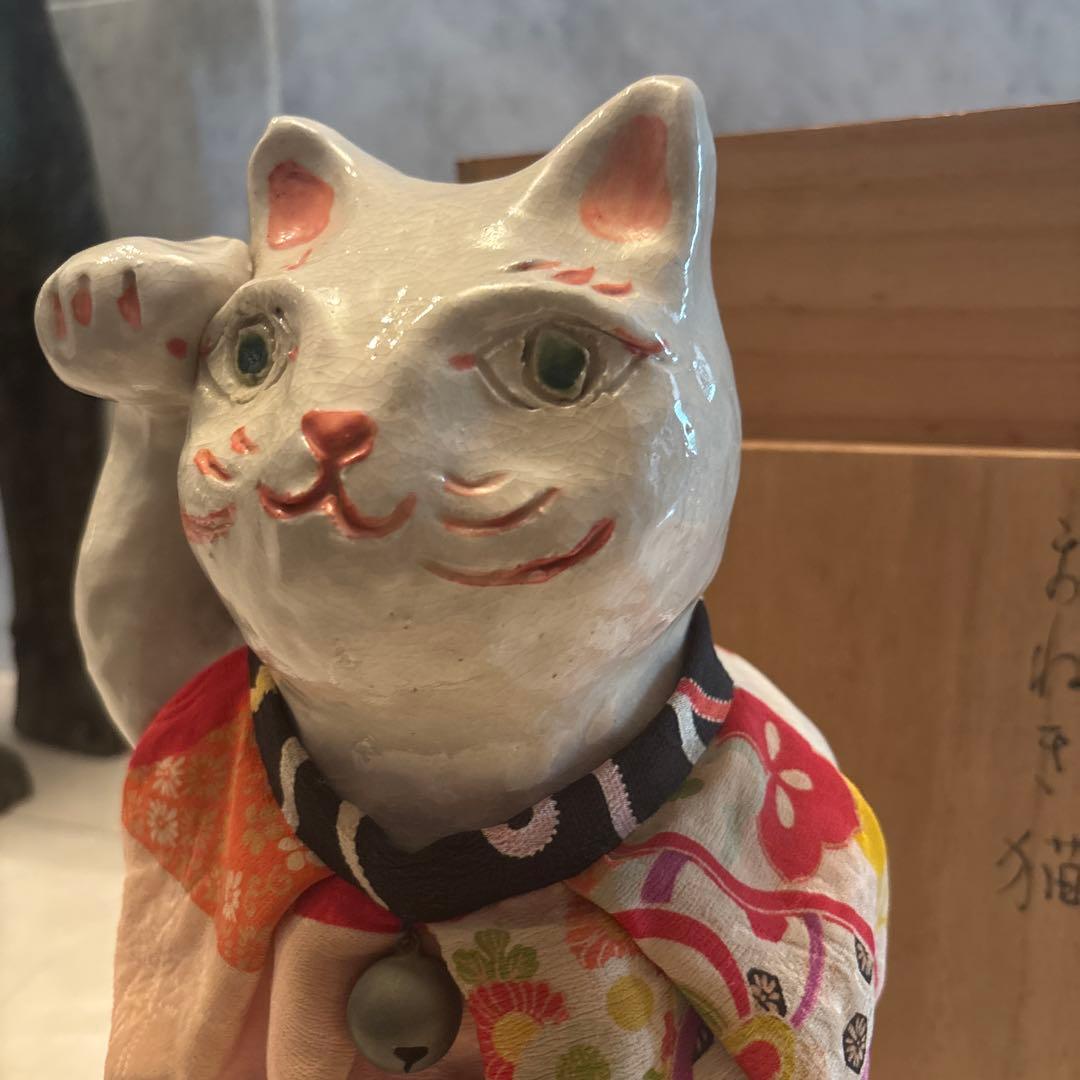 作家さんによる大きな瞳でにっこりと笑う着物の前掛けも美しい招き猫