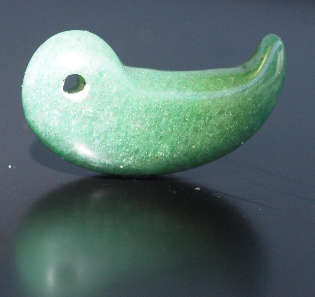 光にかざすと薄緑の細い帯状紋が出現、頭・胴の間には沈線、ずんぐり形の勾玉　沖縄の